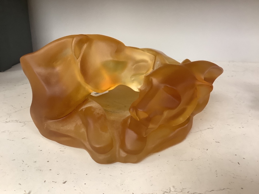 An amber glass dish with a recumbent lioness, signed, 24cm wide, apocryphal Daum mark